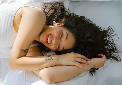 Eine lachende Frau im Bett