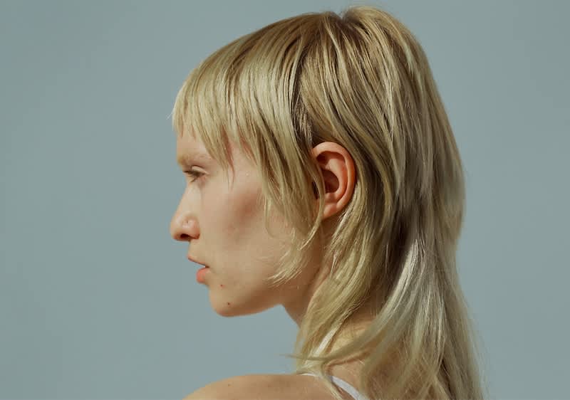 Frisur mit blonden Haaren und Pony von der Seite