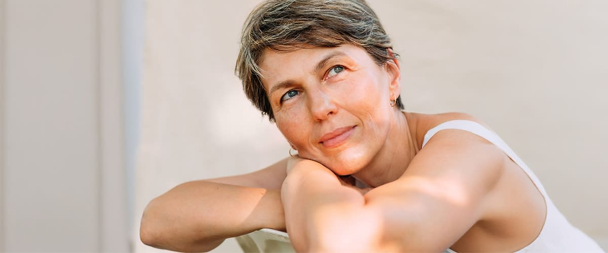 Žena s kratkom kosom, sedi opušteno 