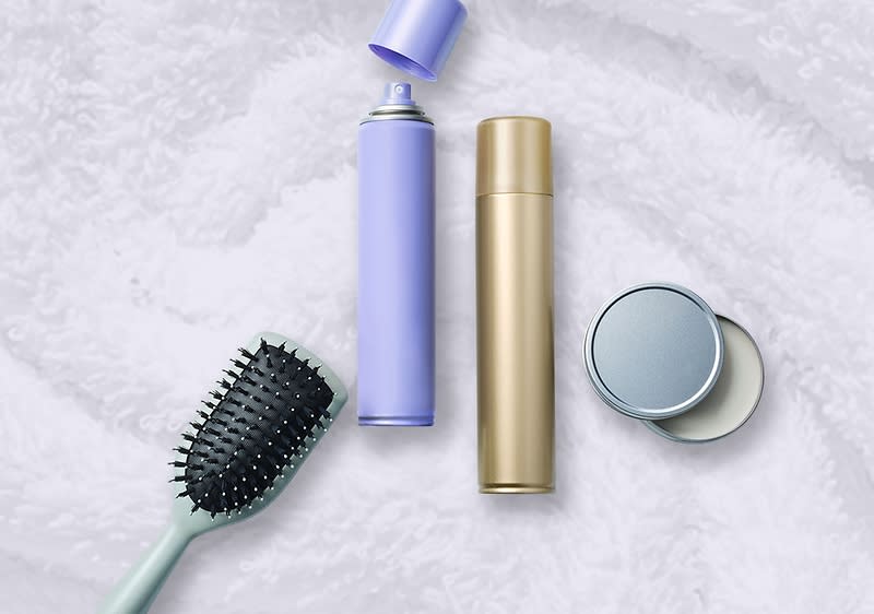 Slika koja prikazuje četku za kosu i kozmetičke proizvode na peškiru