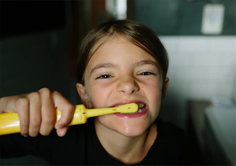 Dete drži žutu četkicu za zube u rucI