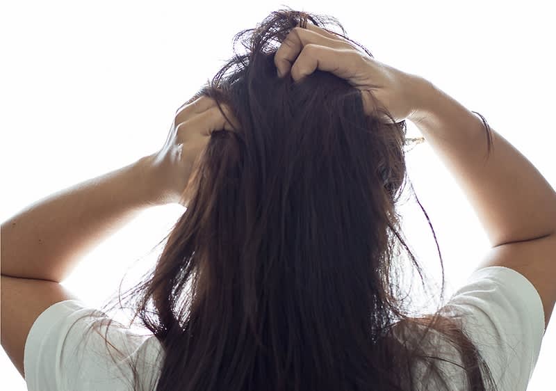 Frau kratzt sich am Kopf