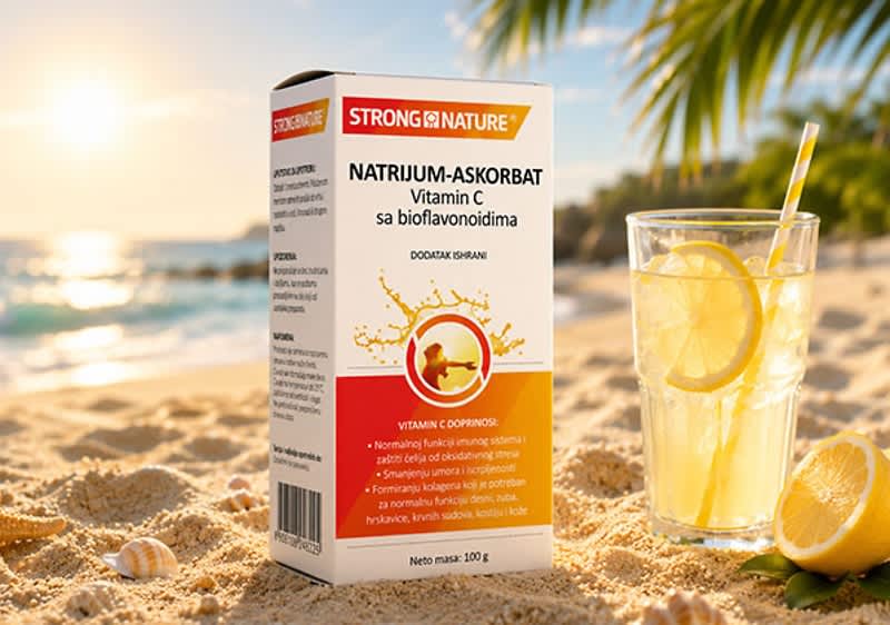 Slika koja prikazuje kutiju natrijum-askorbata vitamina C na peskovitoj plaži pored čaše sa limunadom