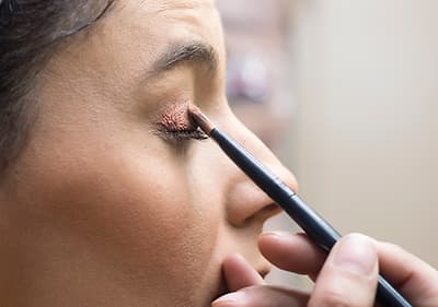 Frau schminkt sich roten Lippenstift ab.