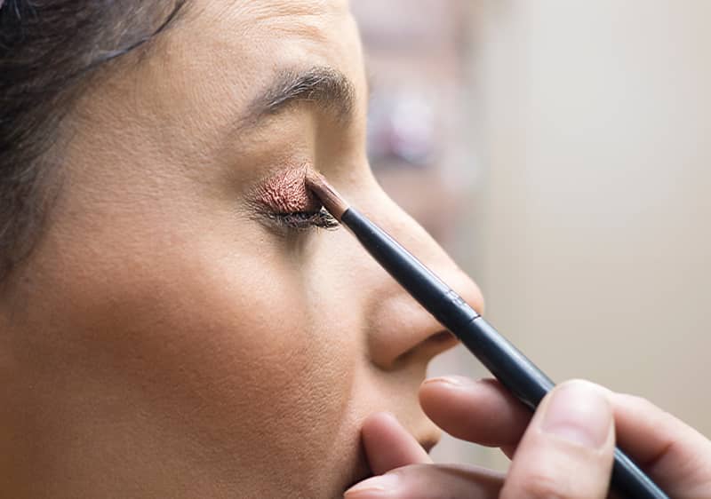 Frau schminkt sich roten Lippenstift ab.