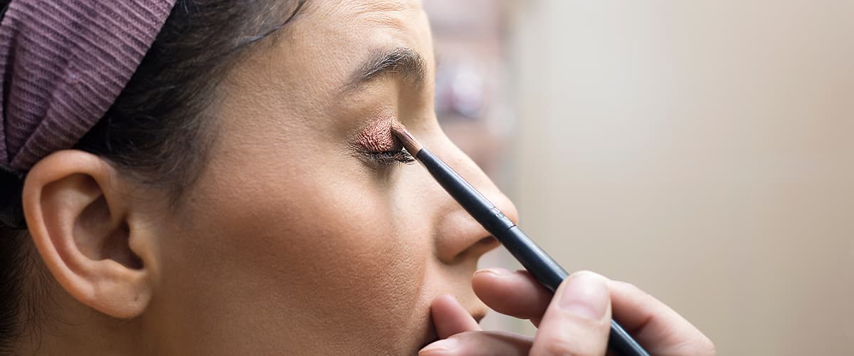 Frau schminkt sich roten Lippenstift ab.