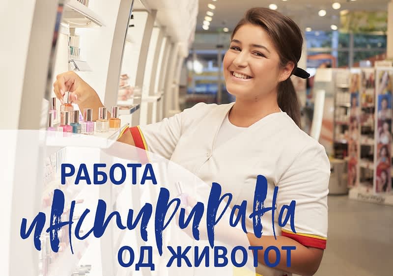 dm Mitarbeiterin schlichtet Regal ein.