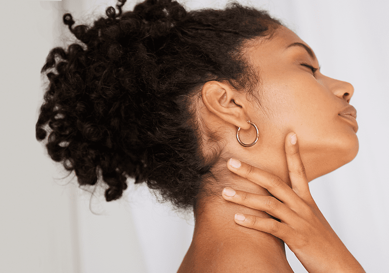 Frau greift sich auf Schilddrüse