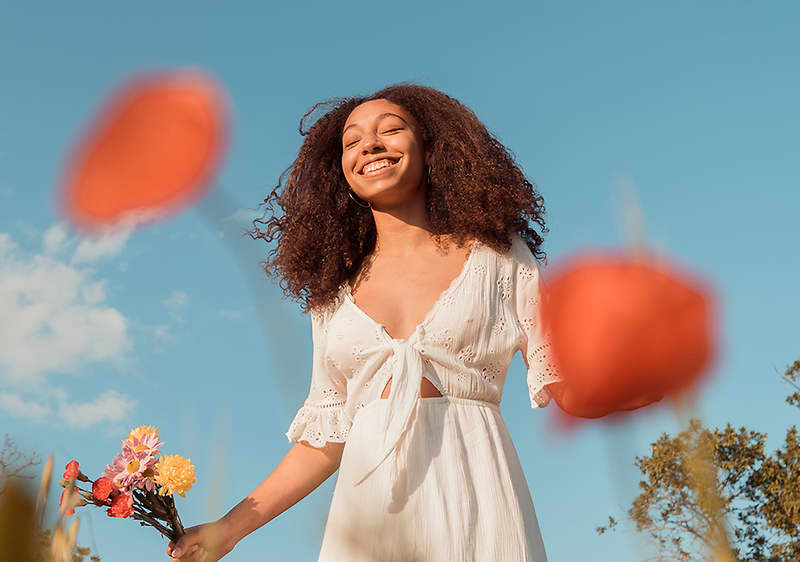 Frau schaut in den Himmel und lächelt
