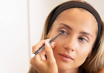 Alt-Text Ženska z naglavnim trakom drži svinčnik za obrvi