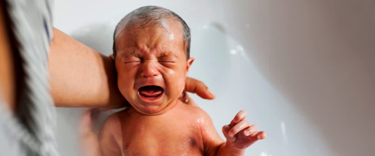 Baby wird gebadet und weint