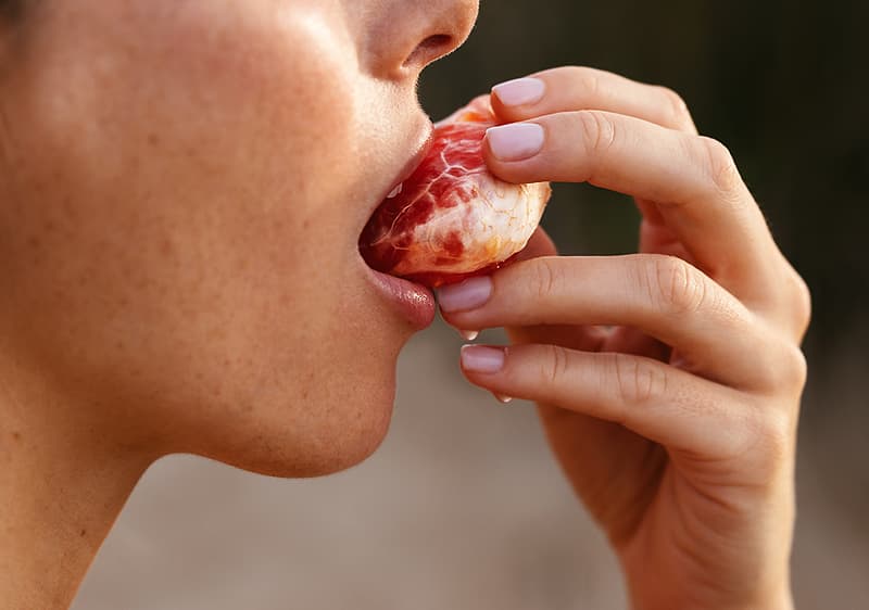 Frau beißt in Obst