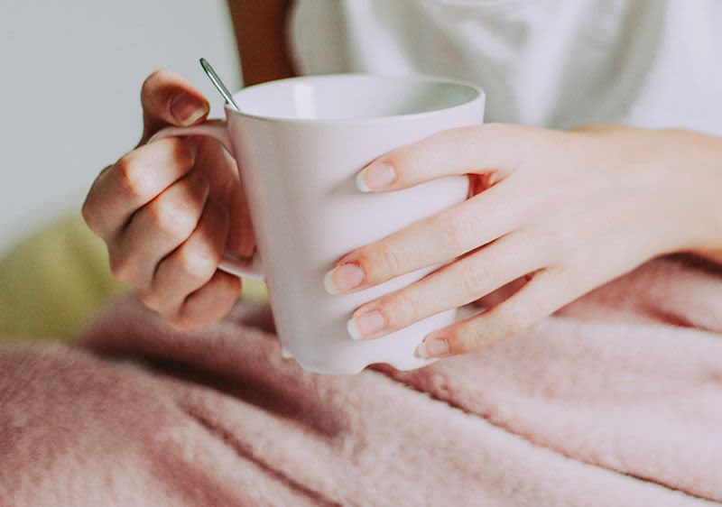 Frau, die Tasse mit Tee in den Händen hält