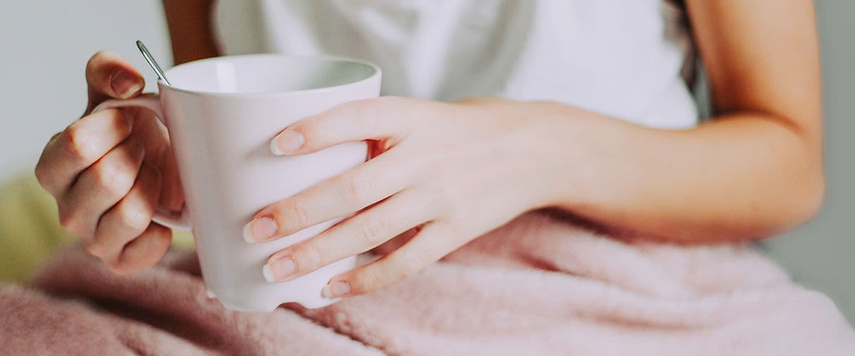 Frau, die Tasse mit Tee in den Händen hält